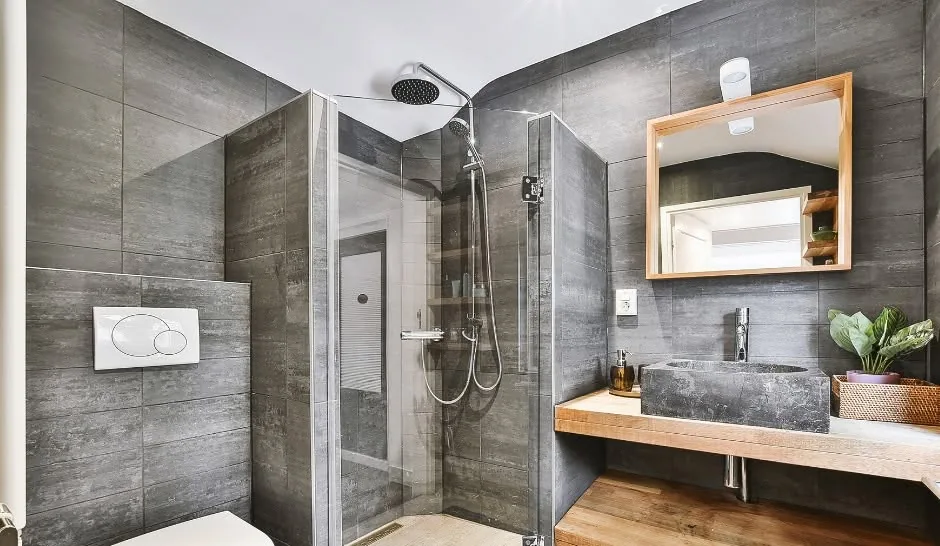 Modern gray bathroom with glass walk-in shower by One Stop Construction in Southern Utah